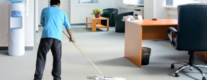 a man wearing blue shirt mopping the office floor