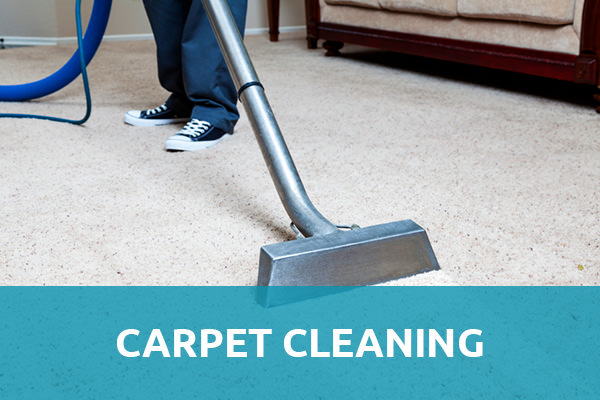 Man wearing a jeans with black and white shoes standing on a white carpet and is holding a steam carpet cleaner with a header title that says "Carpet Cleaning" with blue background and that is one of the services of carpet cleaning Albuquerque.